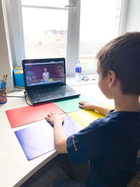 Stavropol, Rusya, 15 Nisan 2020: Çocuklar evdeki bir dizüstü bilgisayarla İnternet üzerinden çalışıyorlar