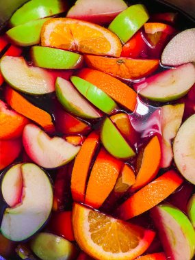 Dilimlenmiş portakallar, elmalar, şeftaliler ve kavun kırmızı şarapta sangria için bir tencerede, üst manzara