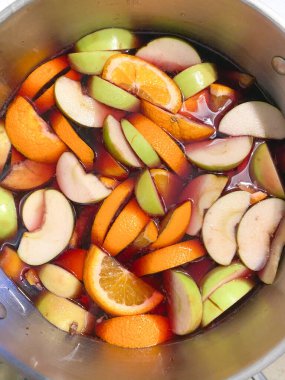 Dilimlenmiş portakallar, elmalar, şeftaliler ve kavun kırmızı şarapta sangria için bir tencerede, üst manzara