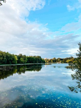 Beyaz bulutlar gölün yüzeyine yansıyor.