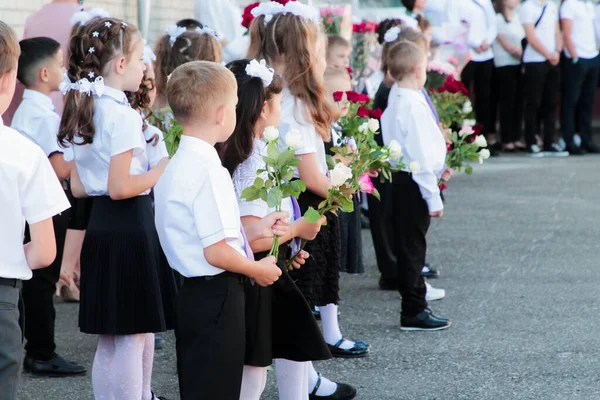 Stanitsa Konstantinovskaya, Rusya, 01 Eylül 2020: 1 Eylül 'deki kutlamalarda okul bahçesinde çiçekli birinci sınıf öğrencileri