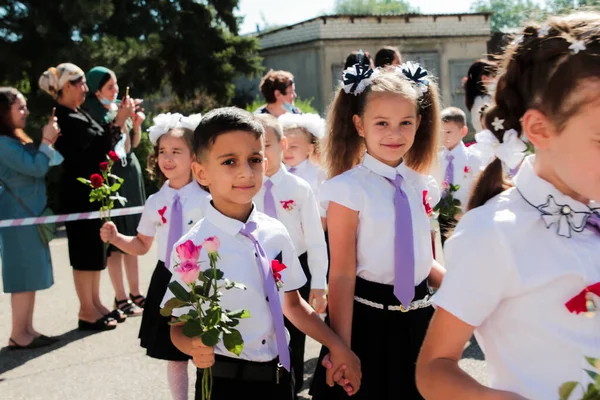 Stanitsa Konstantinovskaya, Rusya, 01 Eylül 2020: 1 Eylül 'deki kutlamalarda okul bahçesinde çiçekli birinci sınıf öğrencileri