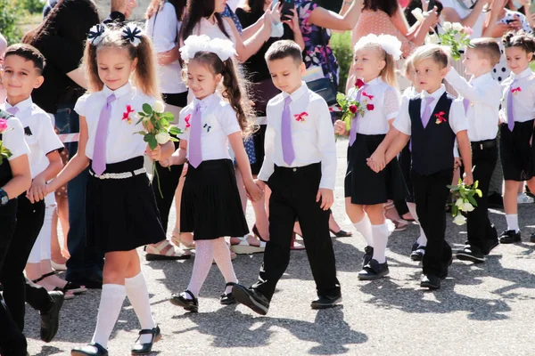 Stanitsa Konstantinovskaya, Rusya, 01 Eylül 2020: 1 Eylül 'deki kutlamalarda okul bahçesinde çiçekli birinci sınıf öğrencileri