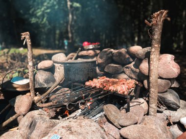 Ateşin üstünde yemek: şiş üzerinde et kızarır, yanında da demir tütsülenmiş bir tencerede lapa pişirilir.