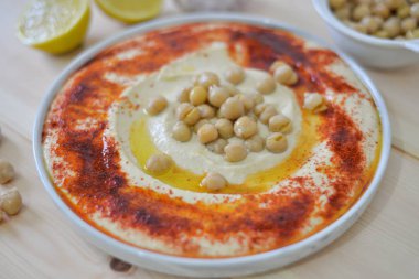 Geleneksel ev yapımı humus rustik masa arka plan kırmızı kırmızı biber zeytin yağı, sarımsak, limon, tahin ve pide ekmek ile görüntü üzerinde tabak