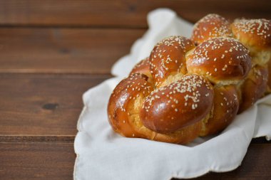 Geleneksel Yahudi tatlı Challah ahşap masa üzerinde ahşap bir tabakta ekmek / kopya alanı ile arka plan