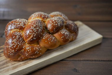 Geleneksel Yahudi tatlı Challah ahşap masa üzerinde ahşap bir tabakta ekmek / kopya alanı ile arka plan