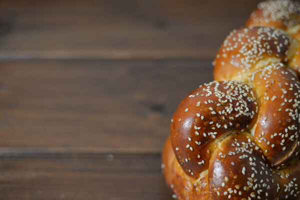 Traditional Jewish sweet Challah bread on a wood plate on wooden table / background with copy space