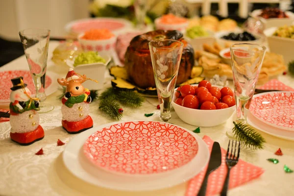 Food table :  traditional Russian food for new years eve traditional Russian salad  - Herring under a fur coat - shuba , salted cherry tomatoes , carrot with mayonnaise