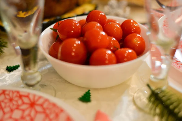 Food table :  traditional Russian food for new years eve traditional Russian salad  - Herring under a fur coat - shuba , salted cherry tomatoes , carrot with mayonnaise