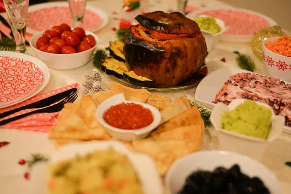 Food table :  traditional Russian food for new years eve traditional Russian salad  - Herring under a fur coat - shuba , salted cherry tomatoes , carrot with mayonnaise