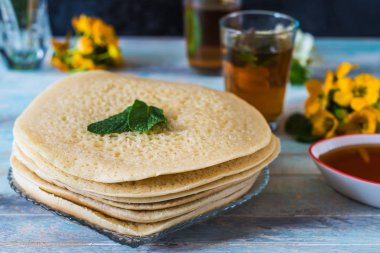 Fas Baghrir krep veya bal ile servis 1000 delikli crapes nana, çayla arka plan çiçekler ile 