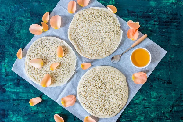 koyu yeşil ahşap arka planda geleneksel Fas krep baghrir