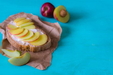 Meyve, şeftali ve yumuşak peynir ile sağlıklı açık sandviçler. yakın kapatın. Sağlıklı beslenme konsepti. kopyalama alanı ile mavi ahşap masa arka plan üzerinde 