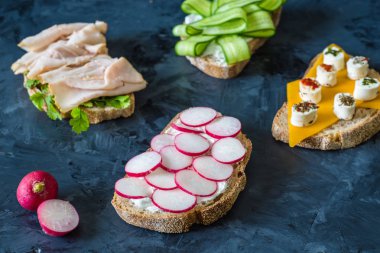 Sebze, havuç, turp, çedar peyniri ve hindi pastırma, ahşap arka plan üzerinde salatalık ile sağlıklı açık sandviç , yakın 