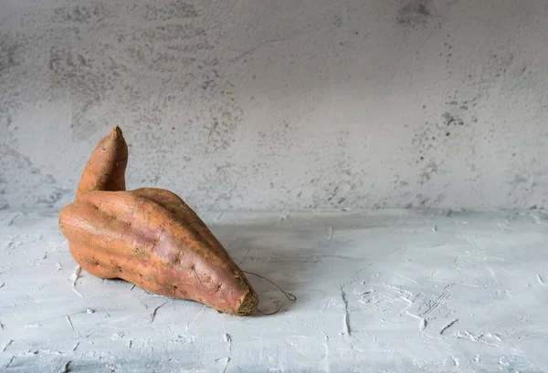 Rå sötpotatis på träbord — Stockfoto