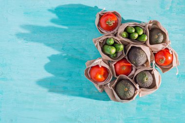 turkuaz arka plan üzerinde hessian çuval içinde pişmemiş sebze