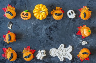 Siyah arkaplanda korkunç semboller olan Cadılar Bayramı kabak kekleri çerçevesi