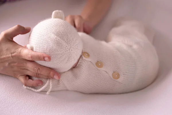 Yeni doğan bebek konsepti fotoğrafçılık hazırlığı, yeni doğmuş şirin bir bebek örgü örmüş, fotoğrafçı elleri de var.. Stok Resim