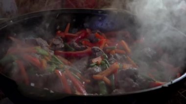 Vegetables and meat are cooked in a pan with steam /         