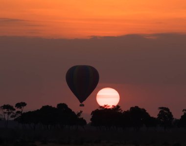 Güzel gün batımı arka plan üzerinde büyük çizgili balon