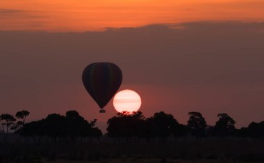 Güzel gün batımı arka plan üzerinde büyük çizgili balon