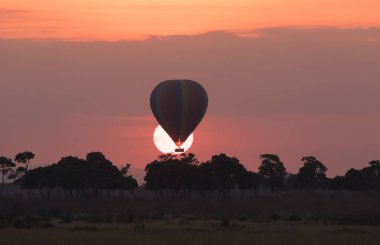 Güzel gün batımı arka plan üzerinde büyük çizgili balon