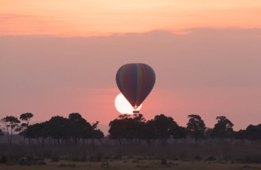 Güzel gün batımı arka plan üzerinde büyük çizgili balon