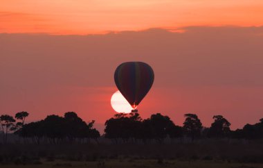 Güzel gün batımı arka plan üzerinde büyük çizgili balon