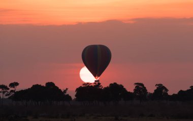 Güzel gün batımı arka plan üzerinde büyük çizgili balon