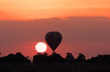 Güzel gün batımı arka plan üzerinde büyük çizgili balon