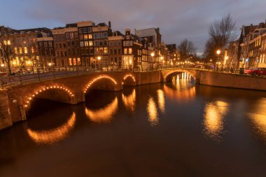 AMSTERDAM / HOLLLAND - HAZİRAN 05 2019: Bu, Amsterdam şehrinin akşam veya gece geç saatlerde çekilmiş görüntüsü. Ateş edildiği sırada gemi kanallardan geçmiş..