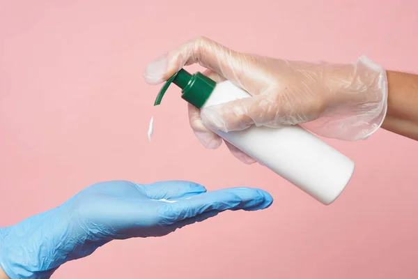 Mão de luva de higiene com um desinfetante em um fundo rosa. Lavagem das mãos para prevenção e saúde do vírus . — Fotografia de Stock