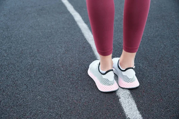 Primer plano de las piernas femeninas en ropa deportiva de moda sobre un fondo de textura azul. El deporte como forma de vida de los ciudadanos. —  Fotos de Stock