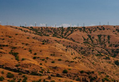 Öğleden sonra tepede rüzgar türbinleri