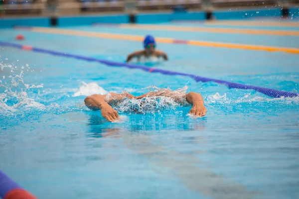 Atletisk man simmar i fjäril stil i poolen med klarblått vatten. — Stockfoto