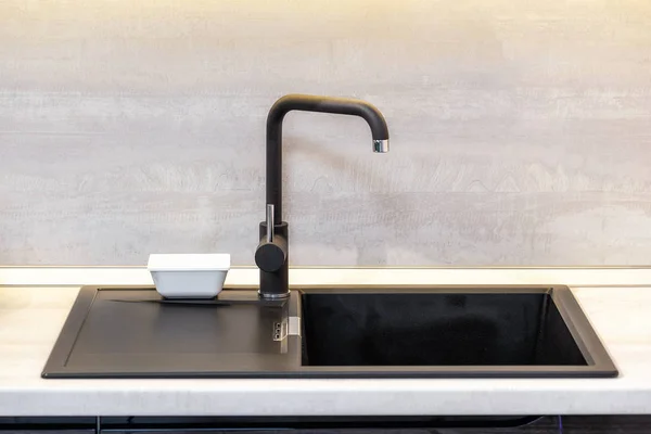 Black Ceramic Sink and Mixer taps on wooden worktop in kitchen room.