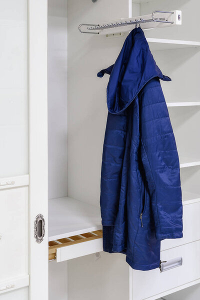Device for storing outerwear in a sliding wardrobe.