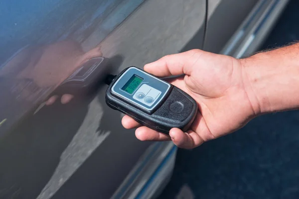 Measuring thickness of the car paint coating with paint thickness gauge