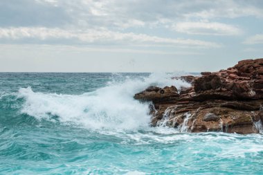 büyük bir sprey şekillendirme kırma taşlık bir sahilde dalgalar