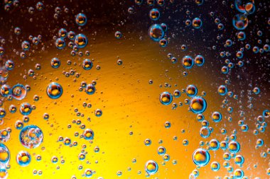 Su yüzeyinde yağ damlaları ve dalgaları olan soyut renkli arkaplan