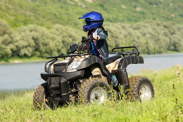 O menino está viajando em um ATV . — Fotografia de Stock