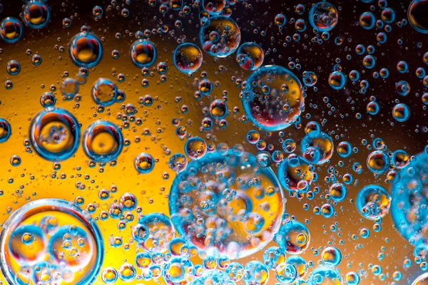 Fundo colorido abstrato com gotas de óleo e ondas na superfície da água — Fotografia de Stock