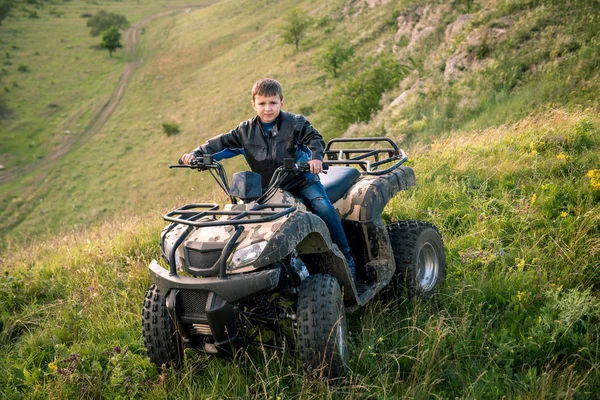 The boy is traveling on an ATV. — Stock Photo, Image
