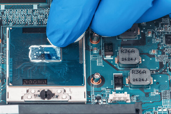 Application of thermal paste on the laptop processor chip for high-quality cooling.