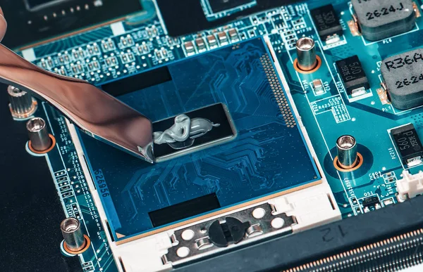 Anwendung von Wärmeleitpaste auf den Laptop-Prozessor-Chip für qualitativ hochwertige Kühlung. — Stockfoto