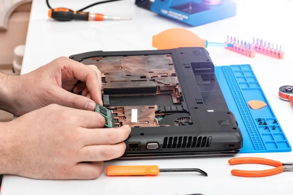 Engenheiro faz desmontagem de RAM para desmontar e reparar um laptop . — Fotografia de Stock