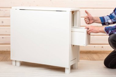 Alıcı montaja hazır katlanır tablo yuvarlanır. Montaja hazır mobilyalar. Ev mobilyalarının montajı