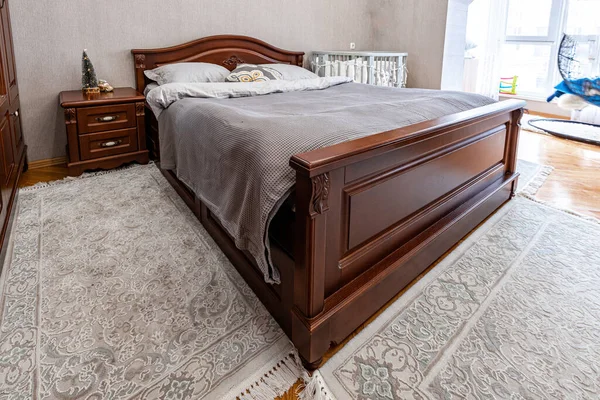 Classic wooden brown bedroom furniture. Soft comfortable bed.
