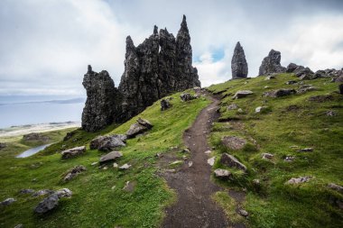 İskoçya 'da bulutlu bir yaz gününde, arka planda deniz olan Skye Adası' ndaki Storr 'un Yaşlı Adamı' na giden kirli bir yol.